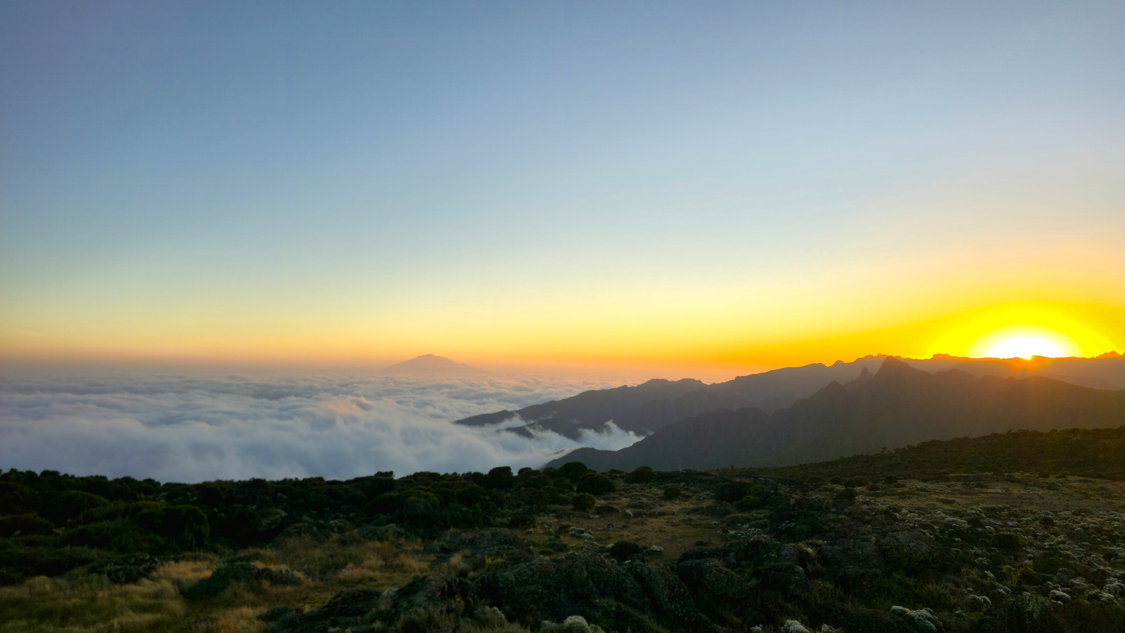 Sunset above the clouds on Kilimanjaro, with Mount Meru in the distance